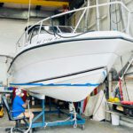 Guy paining boat bottom prep