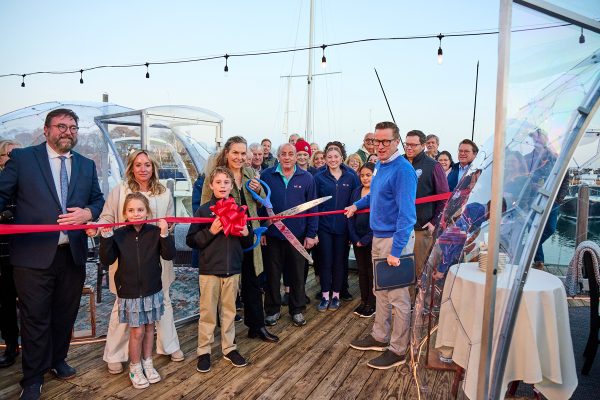 group of people ribbon cutting on the deck with new clear igloo domes