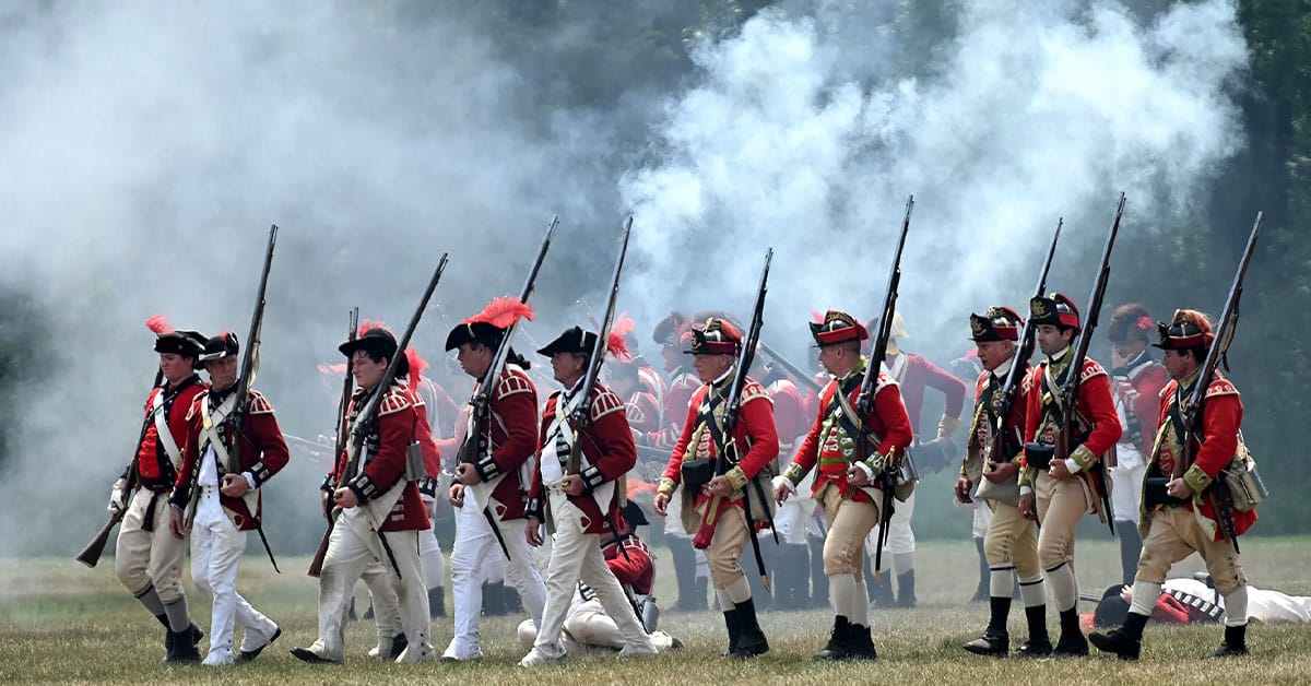 minutemen marching with rifles on shoulders and gun smoke