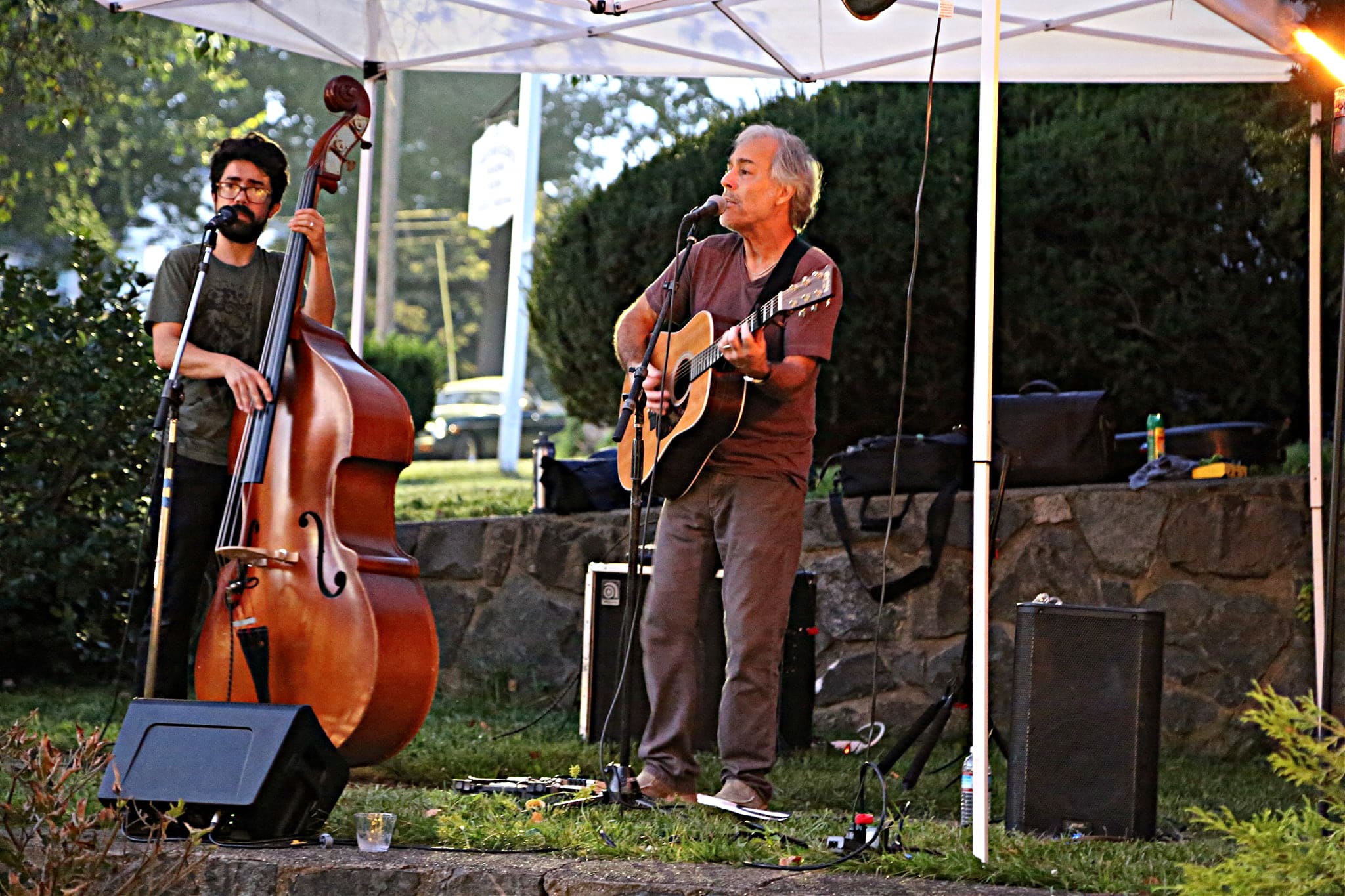 ONE MAN PLAYING STAND UP BASE AND ONE SINING AND PLAYING GUITAR OUTSIDE