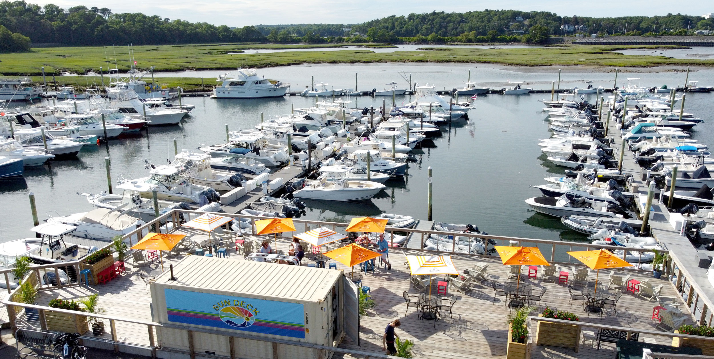 drone shot of a deck umbrella bar overlooking marina