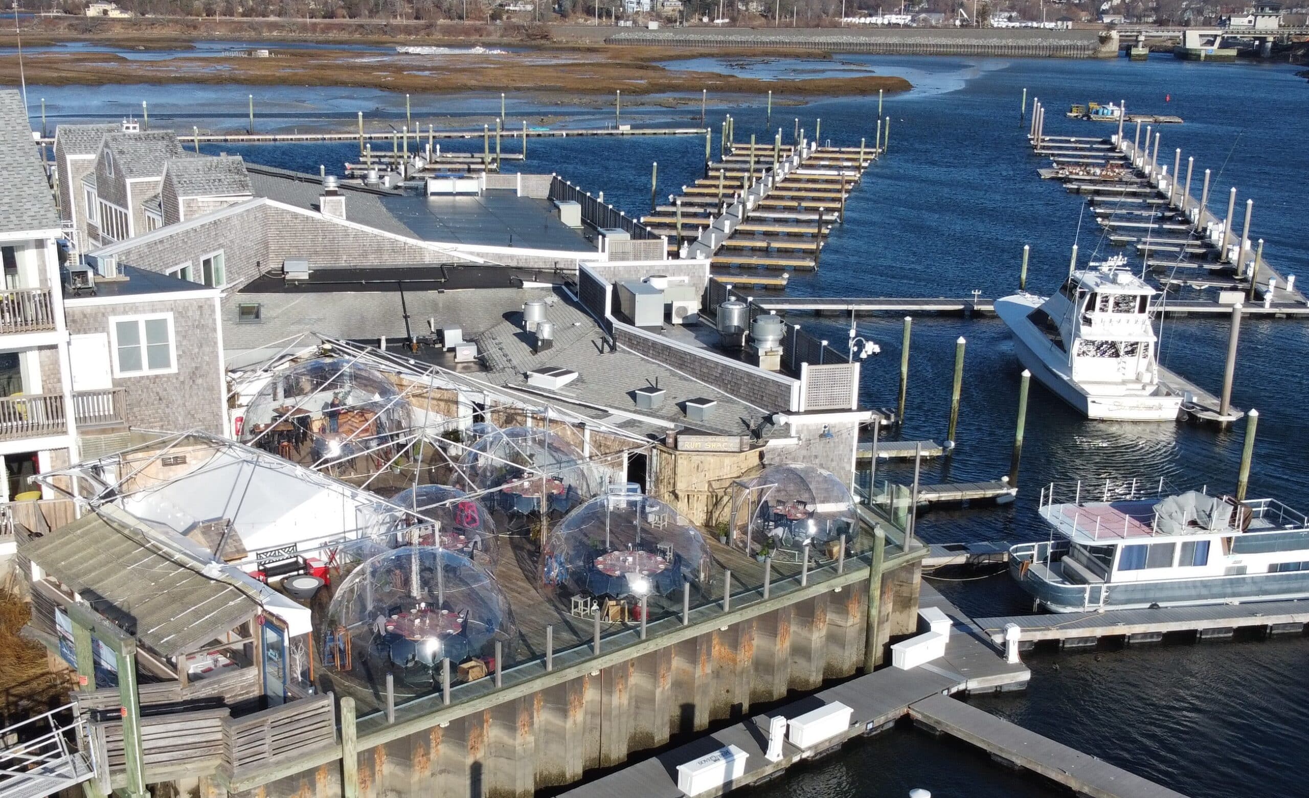 clear domes on a deck at at marina and hotel on the water