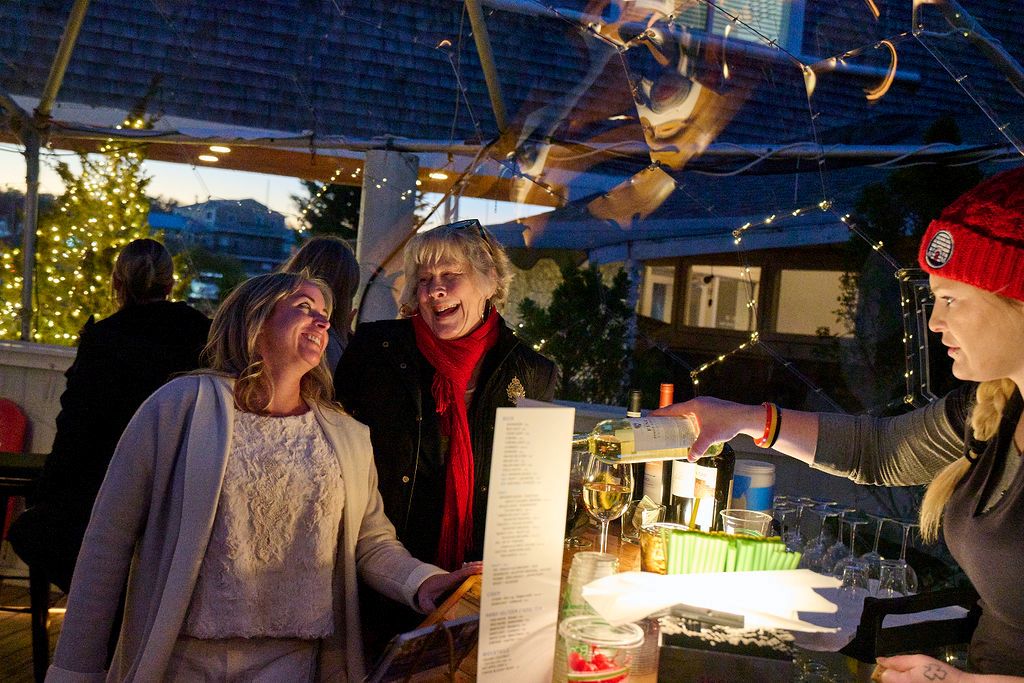 two ladies at a bar at night in clear dome laughing