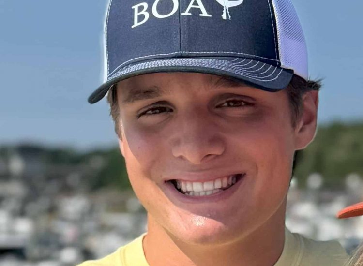 Man with navy hat BOAT on it