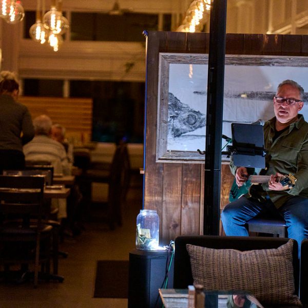 man playing guitar and singing in restaurant