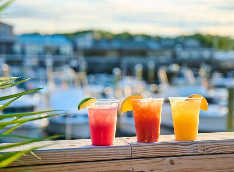 three cocktails on a railing