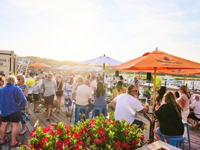 people on a deck under umbrellas with sun shining