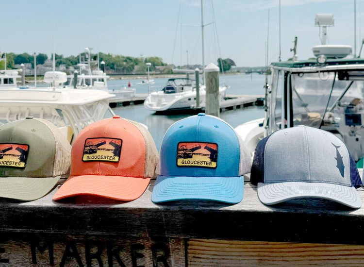 hats on a railing over the water at Cape Ann Marina