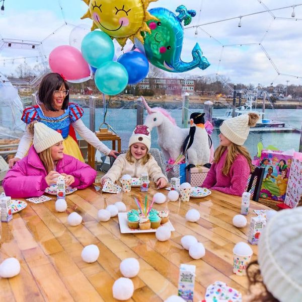girls with hats on and snow white in a clear igloo dome