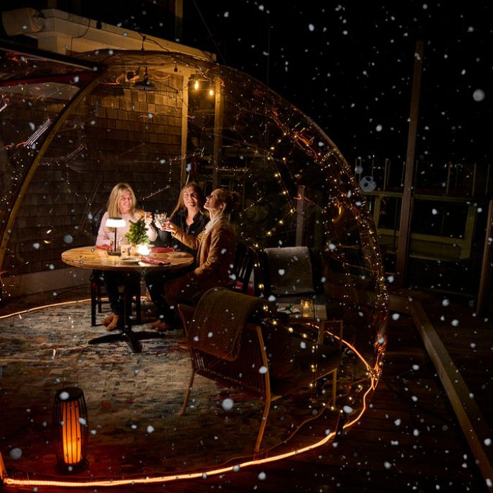 Three ladies at night dining in clear dome igloo