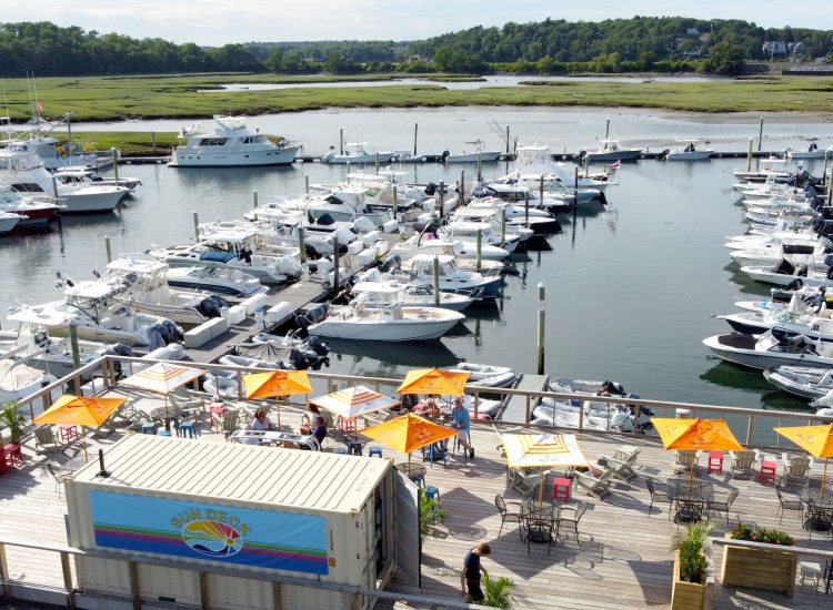 drone shot of a deck umbrella bar overlooking marina