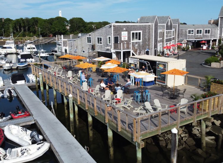 drone shot of a deck umbrella bar overlooking marina