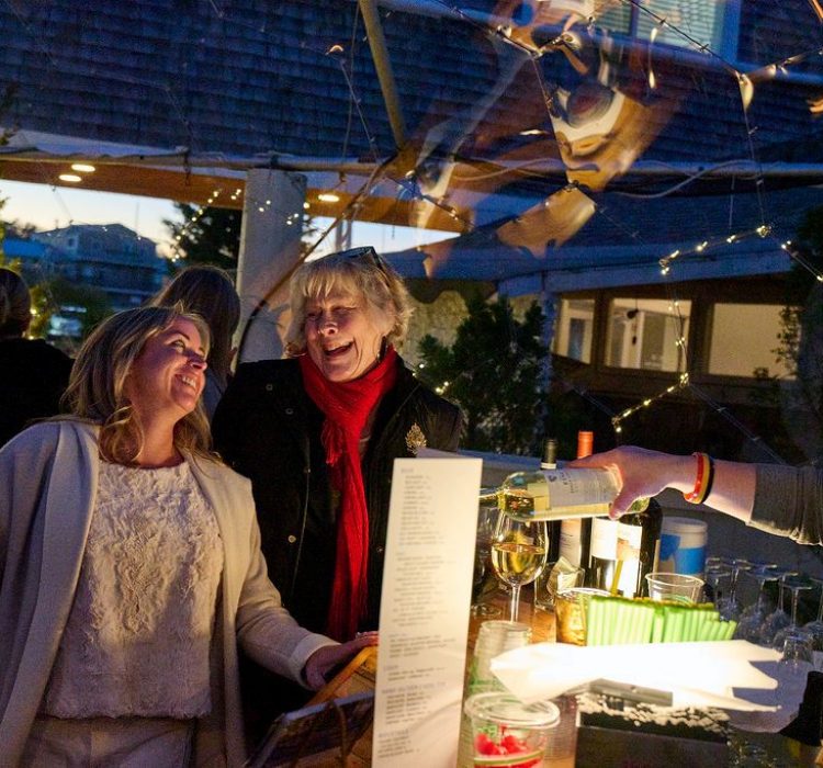 two ladies at a bar at night in clear dome laughing