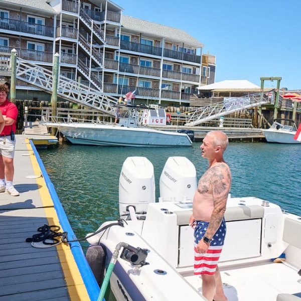 Boat at dock at a marina talking with staff waiting for fuel
