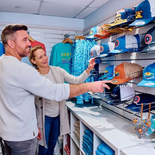 male and female shopping in retail store looking at trucker hats